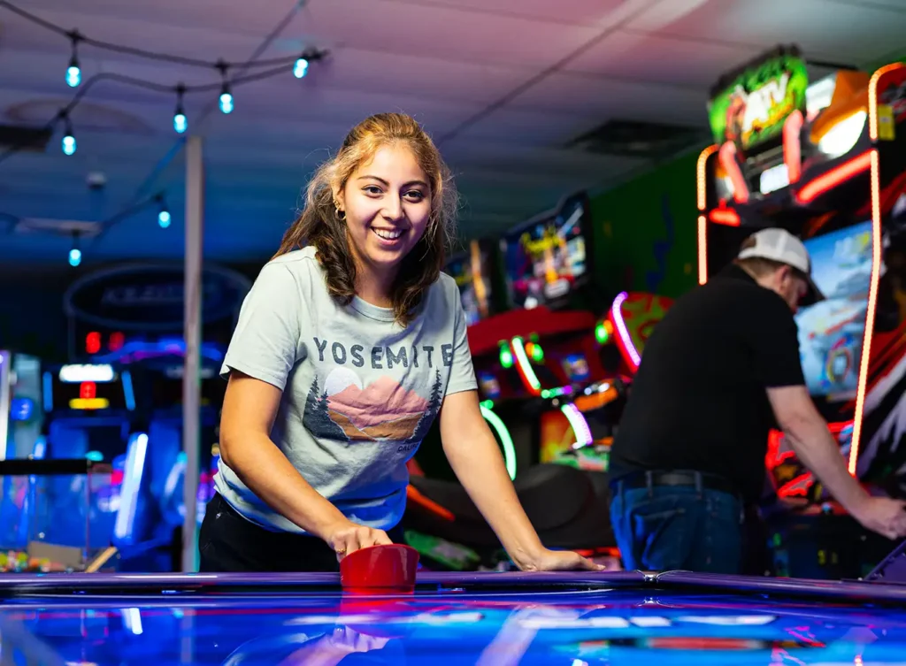 girl playing air hockey at treasure island arcade in fairview heights illinois