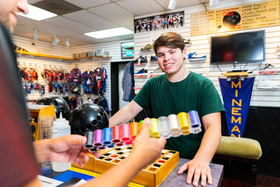 Bowlers' Shoppe employee helping a customer choose bowling ball finger inserts