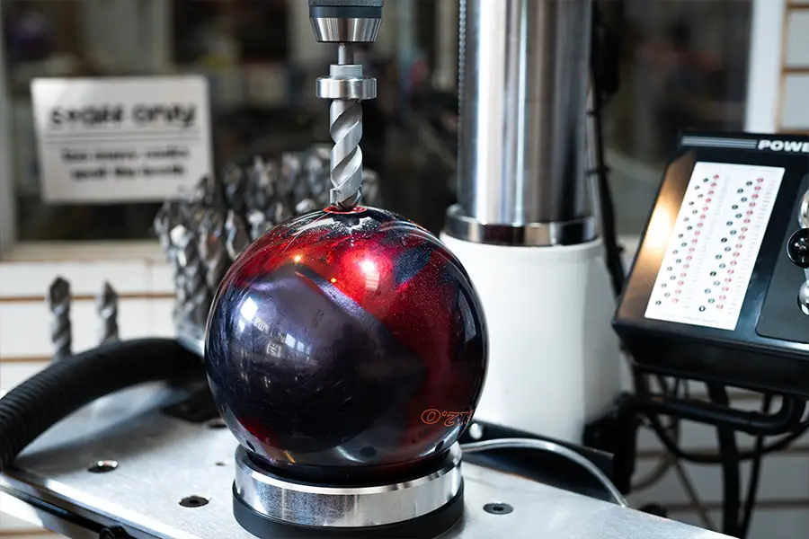 Bowling ball being drilled and fitted with professional pro shop equipment