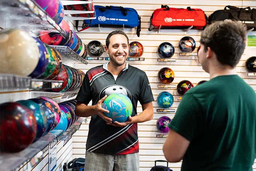 Bowlers' Shoppe employee helping a customer select a bowling ball
