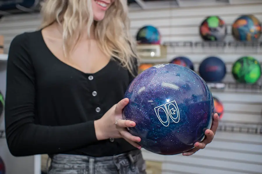 Woman holding a custom bowling ball inside the Bowlers' Shoppe