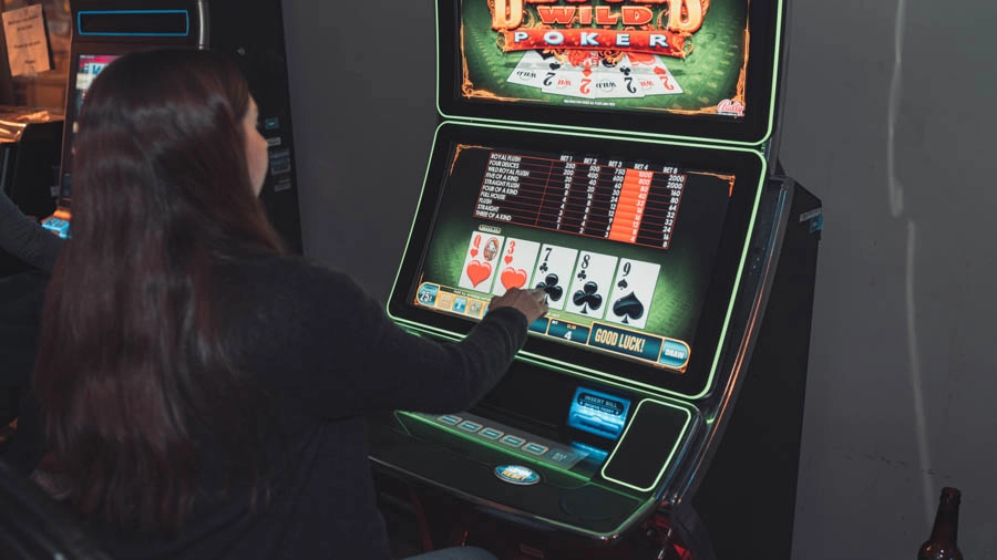 Woman playing a video poker machine at Trixie’s Gaming Parlor