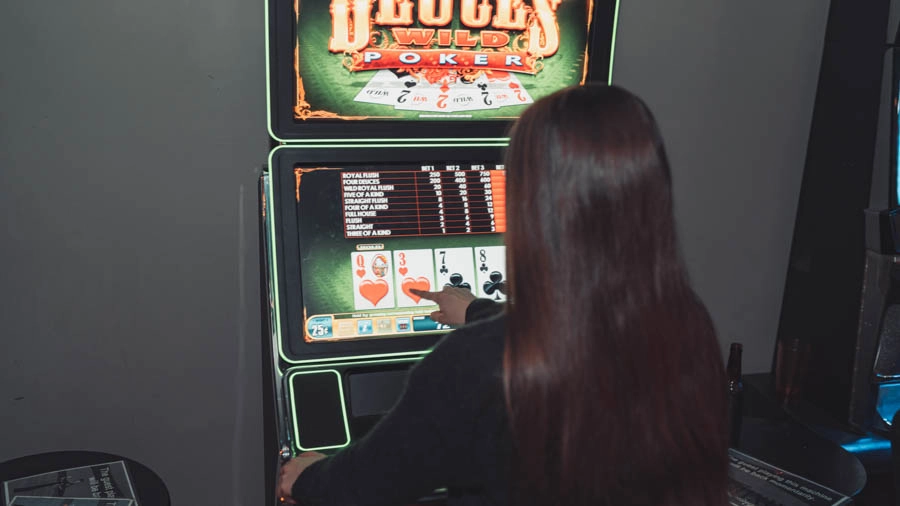 Woman playing a touchscreen video poker machine