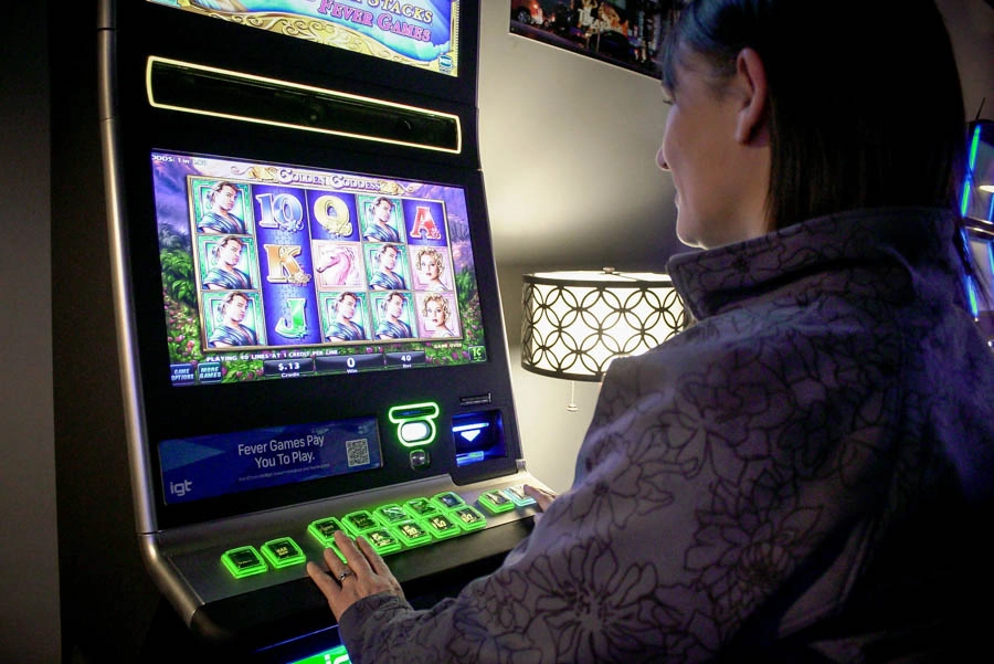 Woman playing a colorful touchscreen gaming machine